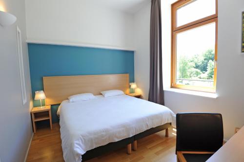 圣沙蒙L Hermitage的一间卧室，配有一张大床和一扇窗户。