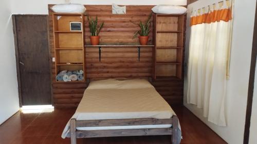 a small room with a bed and shelves at Casa en Cataratas del Iguazú - GUEST HOUSE - in Puerto Iguazú