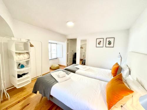 two beds in a room with white walls at Apartments Center Alfama in Lisbon