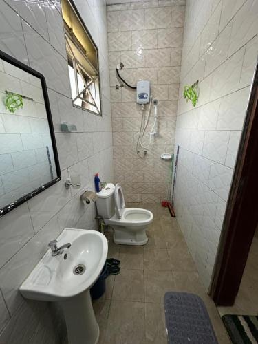a bathroom with a sink and a toilet and a mirror at Aurora two in Kampala