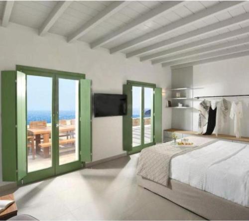 a bedroom with a bed and a view of the ocean at Villa Altheon Mykonos in Mykonos