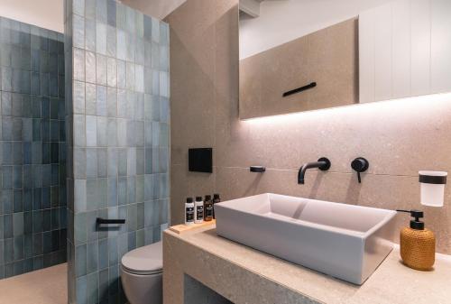 a bathroom with a sink and a toilet at Villa Altheon Mykonos in Mykonos