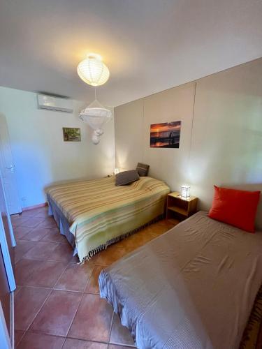 a bedroom with two beds and a chandelier at Les Sucriers in Les Anses-dʼArlets