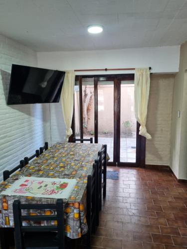 a dining room with a table with chairs and a television at Duplex en mar de ajo Olivia in Mar de Ajó