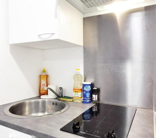 a kitchen counter with a sink and a silver counter top at Studio Near Metro & Marais & Hotel de Ville & Seine in Paris