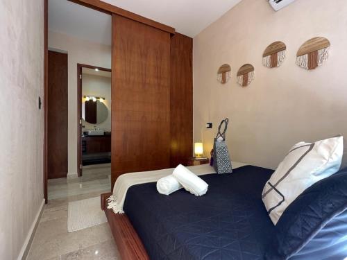 a bedroom with a blue bed with white pillows at Casa Alba in Puerto Morelos
