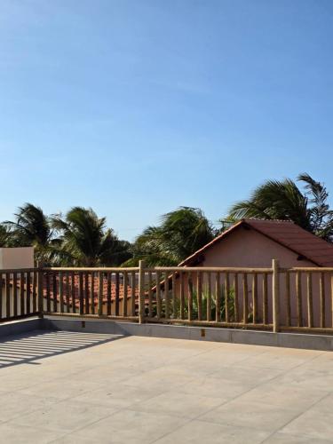 una terraza de madera con una valla y palmeras en Portal do Kite, en Barra Grande