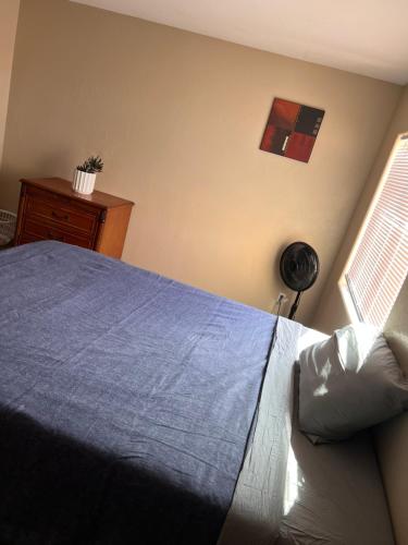 a bedroom with a blue bed and a window at West Valley Spacious Room 2 94th in Phoenix