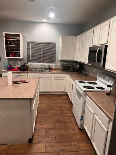 a kitchen with white cabinets and white appliances at West Valley Spacious Room 2 94th in Phoenix