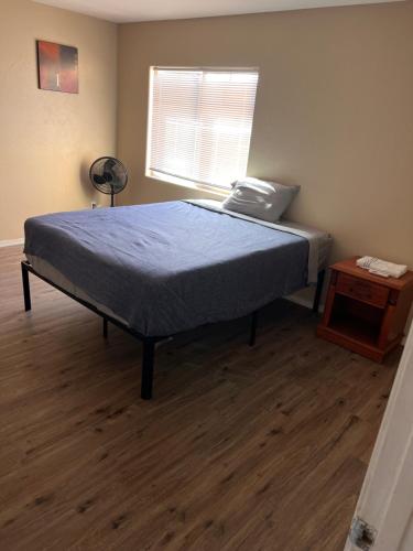 a bedroom with a bed and a night stand and a window at West Valley Spacious Room 2 94th in Phoenix