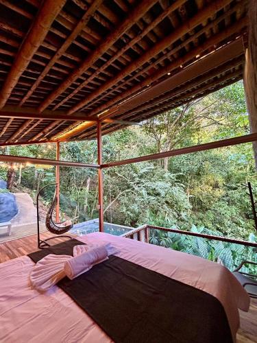 una camera con un grande letto su un balcone di Cabaña El Bosque Encanto Natural y Jacuzzi Privado a Sopetrán