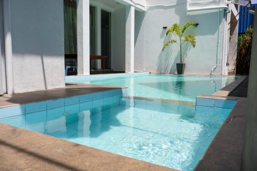 a swimming pool with blue tile in a house at Nirosha Guest House in Galle