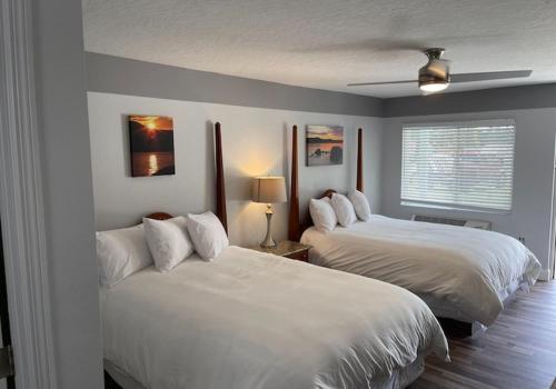 ein Schlafzimmer mit zwei weißen Betten und einem Fenster in der Unterkunft Porky's Lodge, Bar & Grill in Georgetown