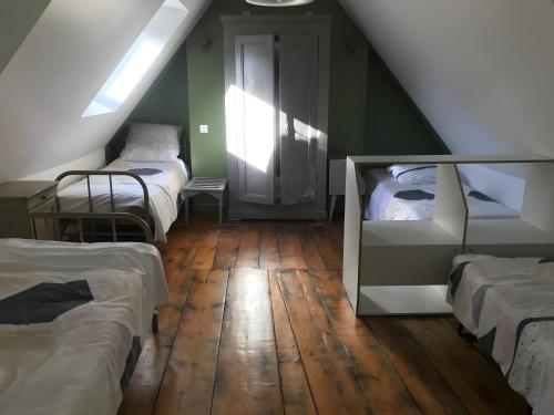 a attic room with three beds and a window at Appartement duplex 180m² in La Bourboule