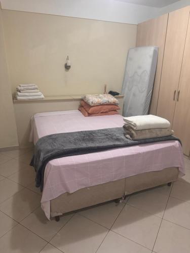 a bedroom with a bed with a chair on it at Flat completo no hotel Comfort em Alphaville in Barueri
