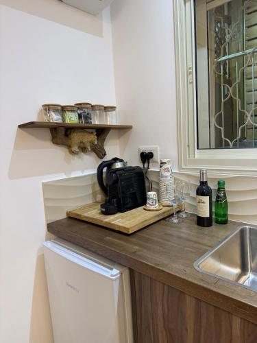 a kitchen counter with a tea kettle on a cutting board at The Colony - By Lime Luxe in Haifa