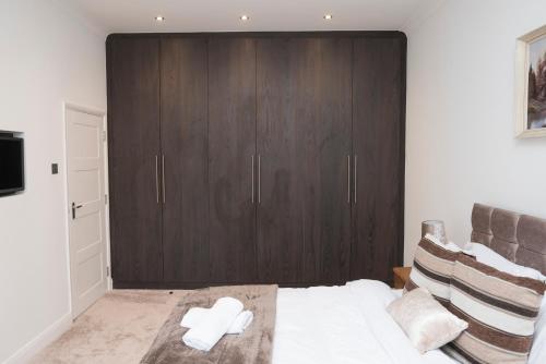 a bedroom with a large wooden cabinet and a bed at Isleworth Apt C in Hounslow