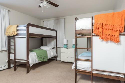 a bedroom with three bunk beds and a ceiling fan at Group Escape: 6BR Hot Tub, Sauna, Game Rm & Garage in Lemeta