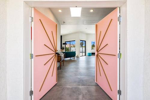 una porta aperta su un corridoio con porte rosa di The Lighthouse- Monthly 5 bd 4 bth Pool & Spa a Palm Springs
