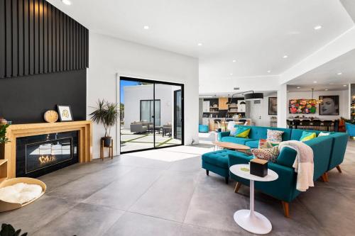 un soggiorno con un divano blu e un camino di The Lighthouse- Monthly 5 bd 4 bth Pool & Spa a Palm Springs