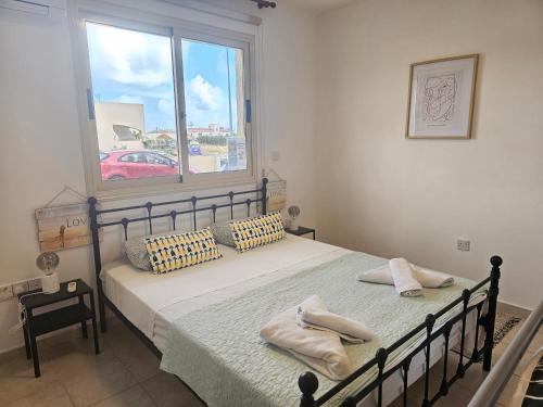 帕福斯Front pool garden apartment的卧室里有一张床，床上放着两条毛巾。