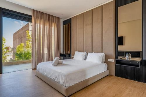 a bedroom with a large bed and a large window at Villa LUMA - Akenza Residence in El Rhechat