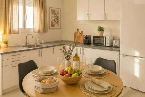 a kitchen with a table with a bowl of fruit at Apartamentos Benalua Alicante - Con Parking - Elegir en el momento de la reserva in Alicante