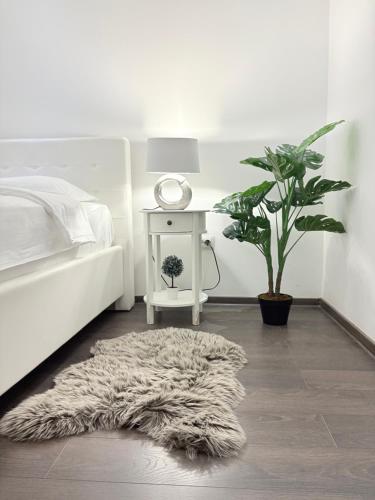 ein Schlafzimmer mit einem weißen Bett und einem Nachttisch mit einer Lampe und einem Fell in der Unterkunft Old City Poema in Braşov