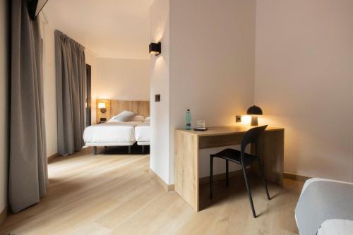 a hotel room with a desk and a bed at Hotel Cervol by Nexta in Andorra la Vella