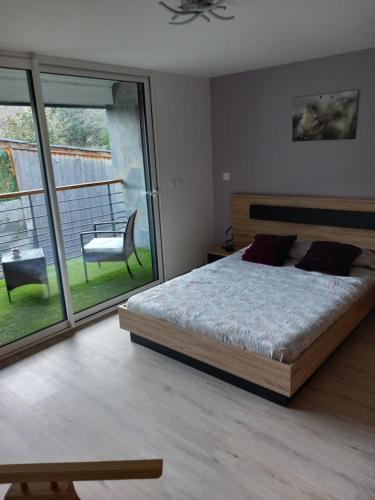 a bedroom with a large bed and a balcony at Maison de Lily in Cier-de-Luchon