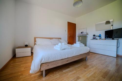 a bedroom with a large white bed and a kitchen at Dimora del 700' in Premariacco