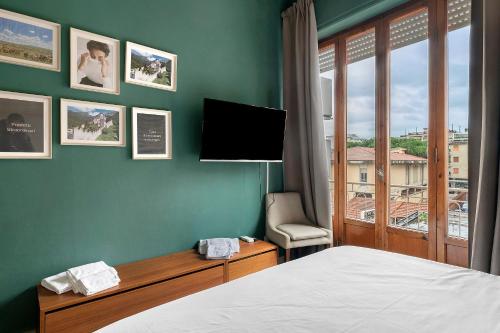 Un dormitorio con una cama y un televisor de pantalla plana. en Casa Rinchiosa, en Marina di Carrara