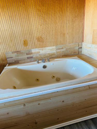 a bath tub in a room with a wooden wall at Country Inn - Licking in Licking