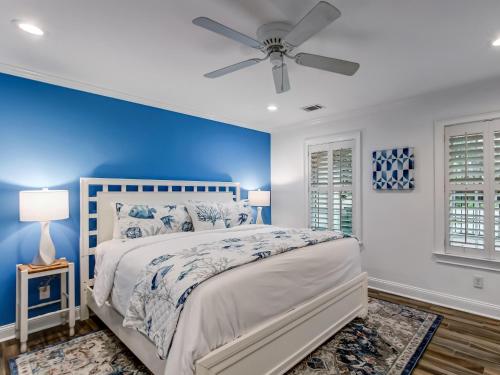 ein blaues Schlafzimmer mit einem Bett und einem Deckenventilator in der Unterkunft Crawford Coastal in Savannah