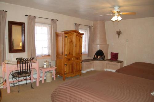 a bedroom with a bed and a fireplace in it at Hotel La Fonda de Taos in Taos