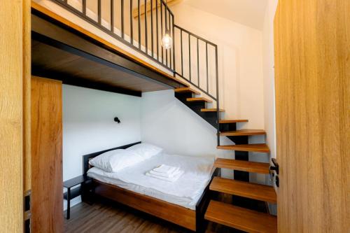 Domki nad potokiem في Lipnica Murowana: غرفة نوم مع سرير بطابقين ودرج