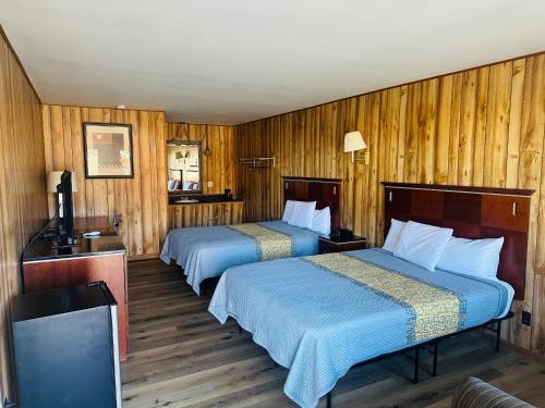 twee bedden in een kamer met houten wanden bij Country Inn - Licking in Licking