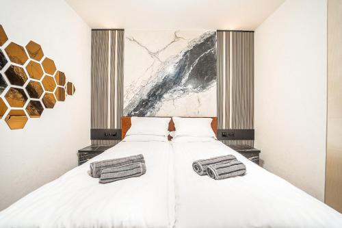 a bedroom with a large white bed with two pillows at Best Central Lux Studio in Bansko