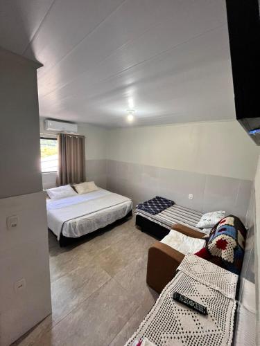 a room with two beds and a couch in it at Pousada Patuzzi in Muçum