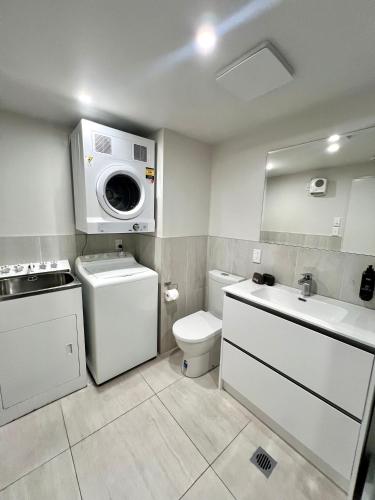 a bathroom with a toilet sink and a washing machine at 6 on Adams in Mount Maunganui