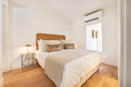 Una habitación blanca con una cama grande con sábanas blancas. en BLQ Charneco 1BDR in Boliqueime by LovelyStay, en Boliqueime