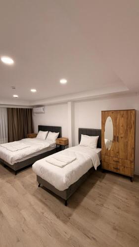 een slaapkamer met twee bedden en een spiegel bij Mütena konaklama in Mudanya