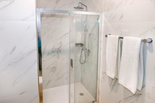a shower with a glass door in a bathroom at Residencial San Fernando in Ponte da Barca