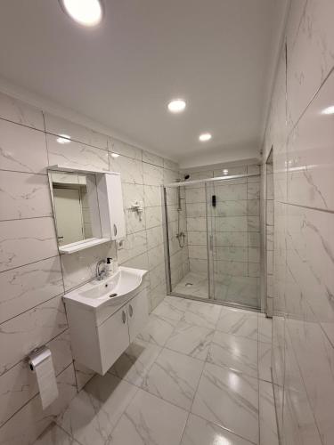 een witte badkamer met een wastafel en een douche bij Mütena konaklama in Mudanya