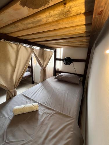 a bedroom with a bed in a room with curtains at Casa Epifania Miraflores hostel in Cali
