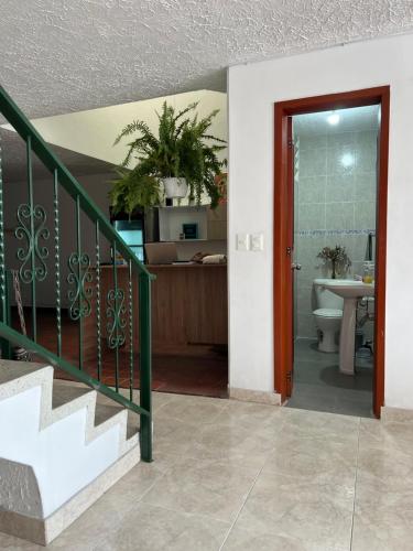 a bathroom with a sink and a toilet and a staircase at Casa Epifania Miraflores hostel in Cali
