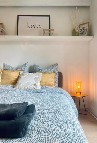 a bedroom with a bed with a blue comforter at Studio spacieux et calme - Parking facile in La Rochefoucauld
