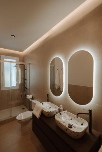a bathroom with a sink and two mirrors at Hotel Asador Las Viñas in Archidona