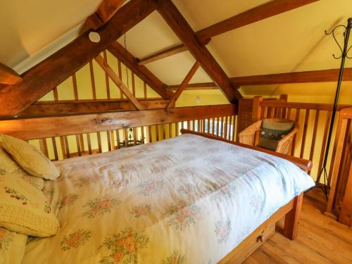 a bedroom with a large bed in a attic at Maggie's Barn in Talgarth