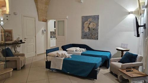 een woonkamer met 2 bedden en een stoel bij Volta Apartment in Mesagne